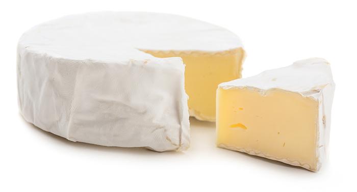 white isolated background, wheel of camembert cheese with a triangular slice cut out