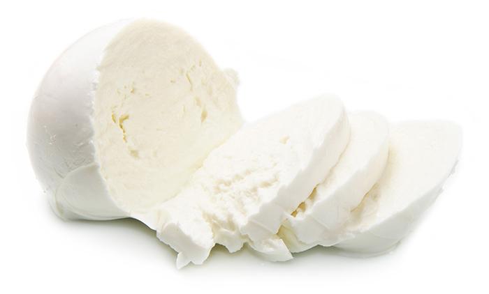 white isolated background, block of white mozzarella cheese with 3 slices cut through the block 